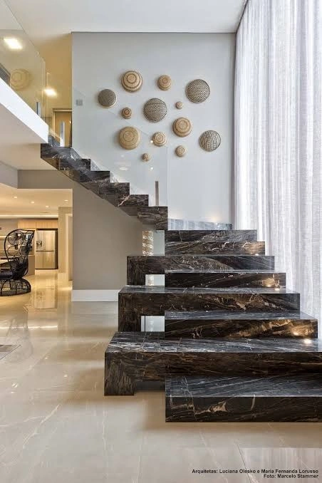 Escada residencial revestida em pedra escura